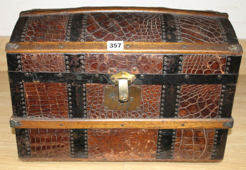 An early 20th century iron and wood bound crocodile covered miniature cabin trunk, with brass latch, length 46cm, height 31.5cm, depth